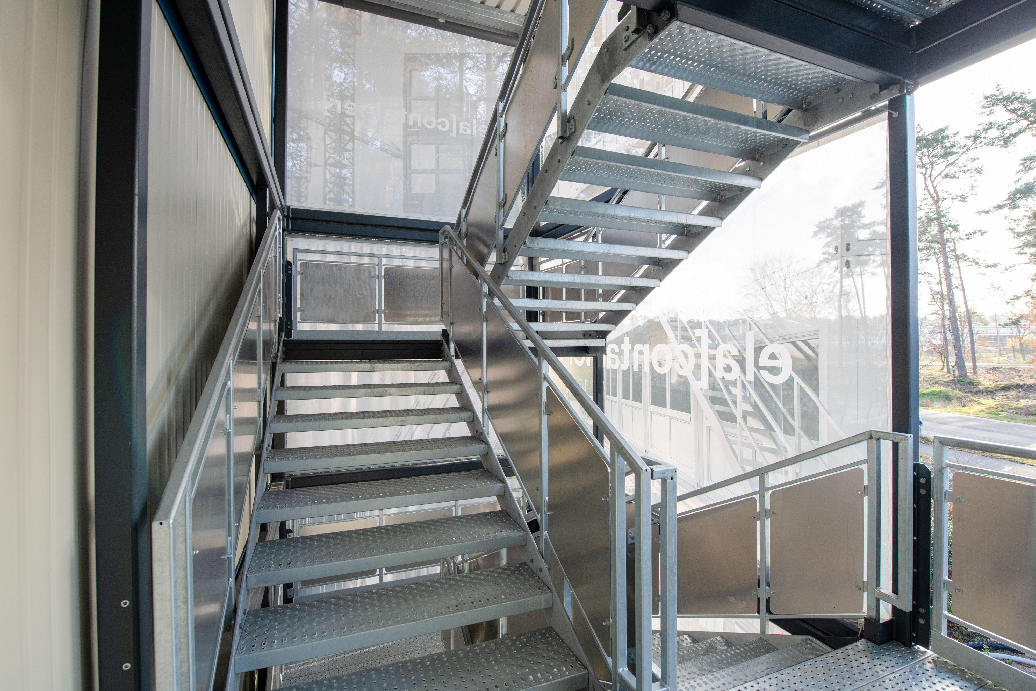 The stairwell is flooded with light. Meshbanners protect against wind and weather.